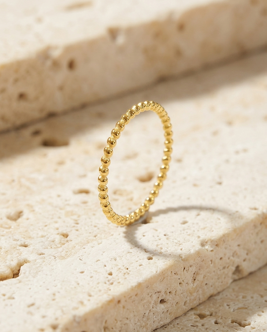 De stapelring met bolletjes van Ambrelle op travertijn